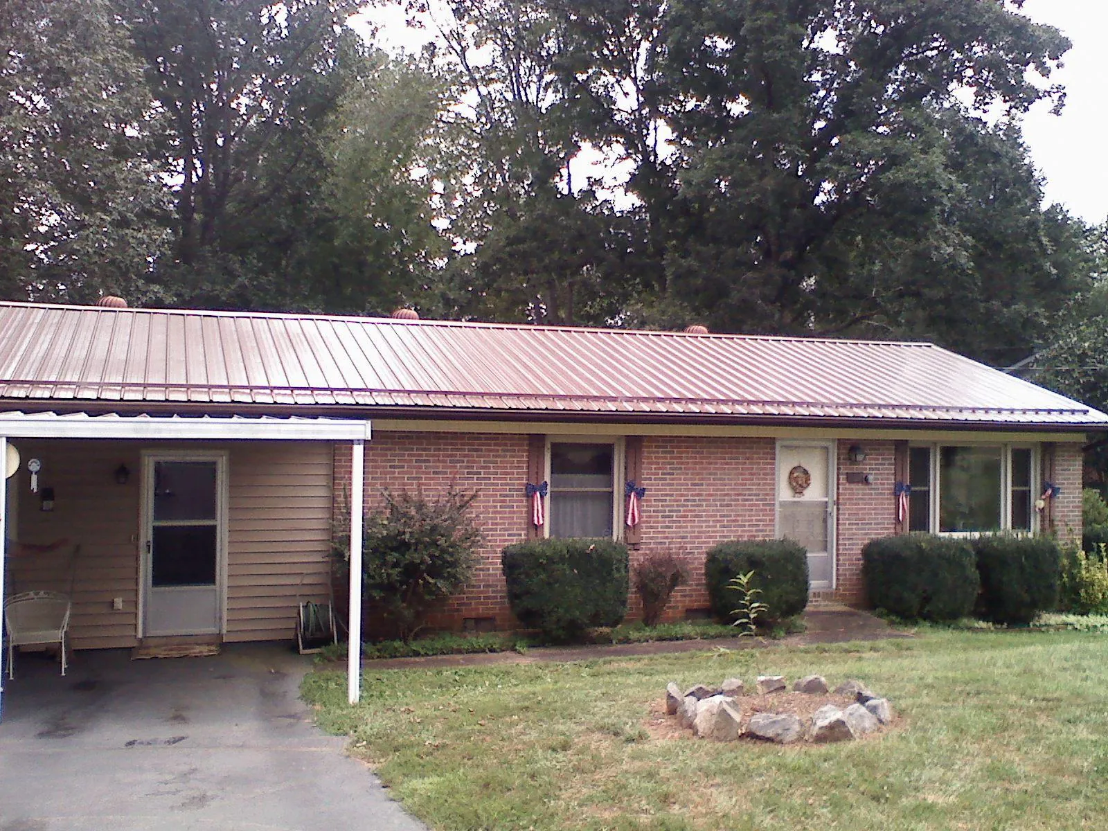 Bronze metal roof and carport on a brick ranch home — Roof Repair work by our crew in Waterloo